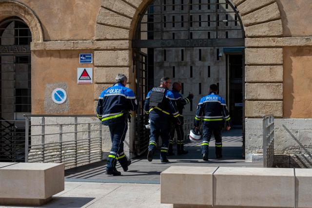 Police officers enter inside the courthouse on the opening day of the trial of members of the DZ Mafia drug trafficking organisation over a double murder committed in 2019, in Aix-en-Provence, southern France on March 23, 2026. (Photo by Elodie CLEMENT / AFP)