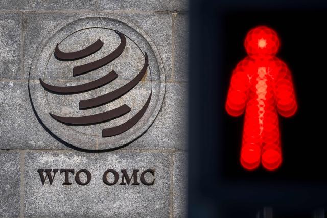This photograph shows a red pedestrian traffic light next to the headquarters of the World Trade Organization (WTO) after the launch of their global trade outlook in Geneva, on March 19, 2026. The Middle East war could weigh heavily on already slowing global trade, the WTO warned saying merchandise trade volume growth could be as low as 1.4 percent this year, compared to 4.6 percent in 2025. (Photo by Fabrice COFFRINI / AFP)