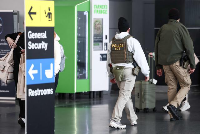 A member of US Immigration and Customs Enforcement (ICE) walks near a security checkpoint at John F. Kennedy International Airport in New York, on March 23, 2026. Immigration agents will be deployed in US airports beginning Monday, aiming to alleviate soaring congestion at security screenings amid a weeks-long budget standoff over President Donald Trump's mass deportation drive, officials said. (Photo by CHARLY TRIBALLEAU / AFP)
