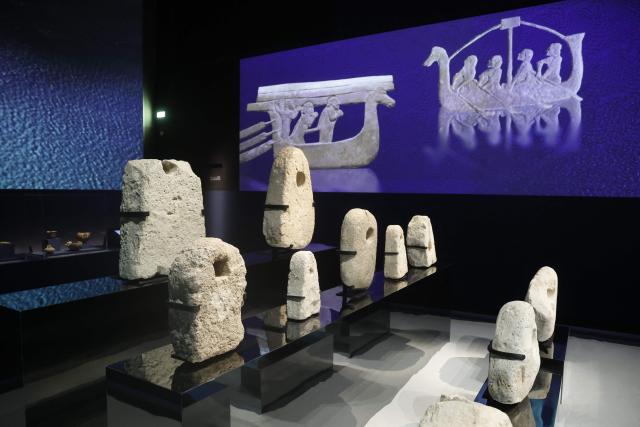 This photograph shows ancient boat anchors as part of the exhibition "Byblos, Lebanon's Millennial City," at the Arab World Institute (IMA) in Paris, on March 23, 2026. France's President inaugurated on March 23, 2026, an exhibition dedicated to Byblos, the ancient city north of Beirut, organized by the Arab World Institute (IMA), at a time when Lebanon is plunged into a new war that has disrupted the arrival of the works being shown in Paris. The exhibition features some 400 pieces. (Photo by Christophe PETIT TESSON / POOL / AFP)