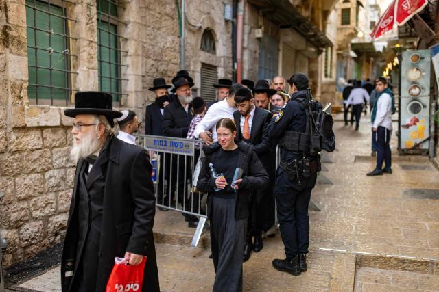 Jewish worshippers are let through an Israeli police checkpoint to enter the Western Wall in Jerusalem's Old City on March 23, 2026. Since the United States and Israel unleashed strikes on Iran on February 28, war has spread across the Middle East, with casualties reported in countries across the region. (Photo by Odd ANDERSEN / AFP) / 