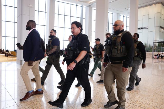 Federal law enforcement agents, including some with US Immigration and Customs Enforcement (ICE), walk through LaGuardia Airport in New York, on March 23, 2026. Immigration agents will be deployed in US airports beginning Monday, aiming to alleviate soaring congestion at security screenings amid a weeks-long budget standoff over President Donald Trump's mass deportation drive, officials said. (Photo by TIMOTHY A.CLARY / AFP)