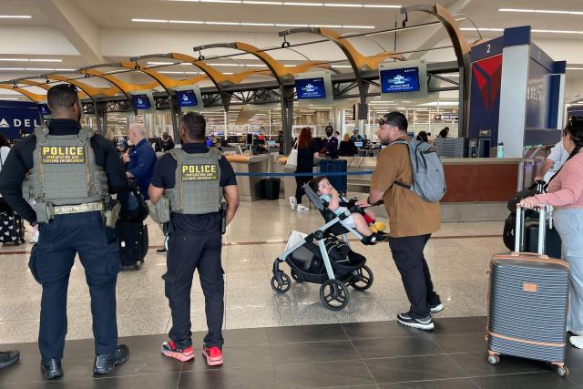 US Immigration and Customs Enforcement (ICE) agents stand watch near the departures hall at Hartsfield-Jackson Atlanta International Airport in Atlanta, Georgia on March 23, 2026. Immigration agents will be deployed in US airports beginning Monday, aiming to alleviate soaring congestion at security screenings amid a weeks-long budget standoff over President Donald Trump's mass deportation drive, officials said. (Photo by John Falchetto / AFP)