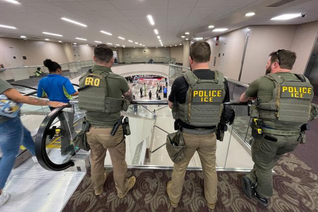 US Immigration and Customs Enforcement (ICE) agents stand watch near the departures hall at Hartsfield-Jackson Atlanta International Airport in Atlanta, Georgia on March 23, 2026. Immigration agents will be deployed in US airports beginning Monday, aiming to alleviate soaring congestion at security screenings amid a weeks-long budget standoff over President Donald Trump's mass deportation drive, officials said. (Photo by John Falchetto / AFP)