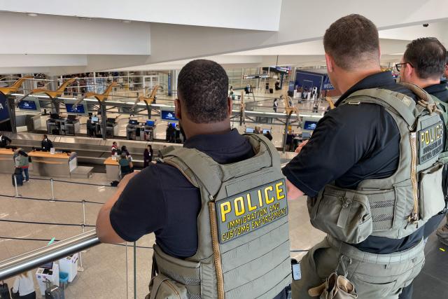 US Immigration and Customs Enforcement (ICE) agents stand watch near the departures hall at Hartsfield-Jackson Atlanta International Airport in Atlanta, Georgia on March 23, 2026. Immigration agents will be deployed in US airports beginning Monday, aiming to alleviate soaring congestion at security screenings amid a weeks-long budget standoff over President Donald Trump's mass deportation drive, officials said. (Photo by John Falchetto / AFP)