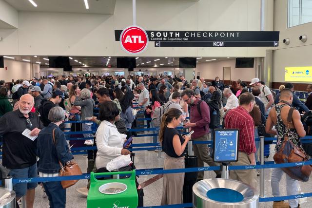 Travelers wait in line at a security checkpoint at Hartsfield-Jackson Atlanta International Airport in Atlanta, Georgia on March 23, 2026. Immigration agents will be deployed in US airports beginning Monday, aiming to alleviate soaring congestion at security screenings amid a weeks-long budget standoff over President Donald Trump's mass deportation drive, officials said. (Photo by John Falchetto / AFP)