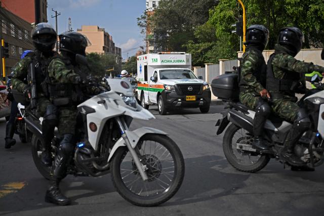 An ambulance arrives at the military hospital in Bogota on March 23, 2026, after an Air Force Hercules crashed during takeoff in Puerto Leguizamo, near the southern border with Ecuador. A Colombian military plane carrying 125 troops and crew crashed on take off on March 23, 2026, with as many as 80 people aboard feared dead. The Hercules aircraft went down shortly after departure from Puerto Leguizamo, near the southern border with Ecuador, strewing burning wreckage on the jungle floor. (Photo by RAUL ARBOLEDA / AFP)