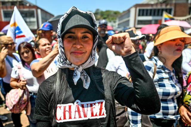 An activist raises her fist during a march demanding the complete lifting of US sanctions, in Caracas, on March 23, 2026. (Photo by Juan BARRETO / AFP)