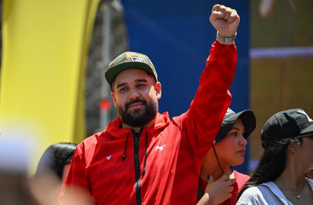 Venezuelan deputy Nicolas Maduro Guerra, son of ousted President Nicolas Maduro, raises his fist during a march demanding the complete lifting of US sanctions, in Caracas, on March 23, 2026. (Photo by Juan BARRETO / AFP)