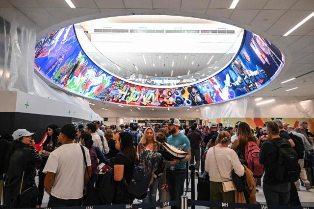 Travelers wait in long security lines at George Bush Intercontinental Airport in Houston, Texas on March 23, 2026. (Photo by RONALDO SCHEMIDT / AFP)