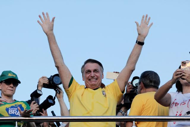 (FILES) Brazil's former President (2019-2022) Jair Bolsonaro waves at supporters during a march to demand amnesty for people convicted over a failed rightwing insurrection on January 8, 2023, in Brasilia, Brazil, on May 7, 2025. Former Brazilian President Jair Bolsonaro, who was hospitalized with bronchopneumonia, was released from intensive care on March 23, 2026, one of his doctors reported, as he awaits the Supreme Court’s decision on whether to grant him house arrest. (Photo by SERGIO LIMA / AFP)