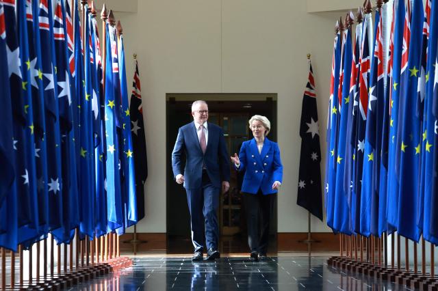 European Commission President Ursula von der Leyen (R) and Australian Prime Minister Anthony Albanese walk through the corridors of Parliament House in Canberra on March 24, 2026. (Photo by DAVID GRAY / AFP)