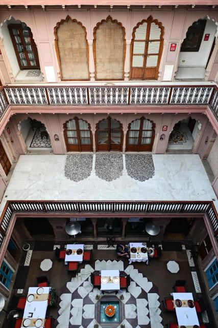 This photograph taken on February 2, 2026 shows visitors dining at the Dharampura Haveli, an 18th-century haveli-turned-heritage hotel in the old quarters of Delhi. Once the grand residences of Mughal-era nobility, the Indian capital's haveli homes now stand at fragile crossroads -- a handful lovingly restored but many more sliding quietly into ruin. (Photo by Manan VATSYAYANA / AFP)