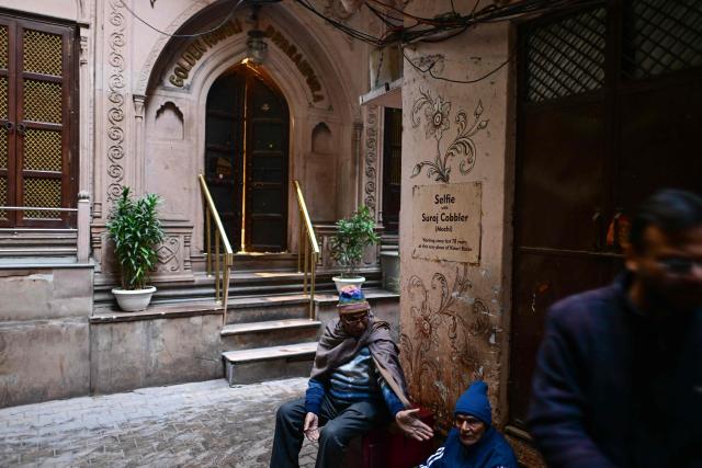 This photograph taken on February 2, 2026 shows people sitting outside the Golden Haveli, an 18th-century haveli-turned-heritage hotel in the old quarters of Delhi. Once the grand residences of Mughal-era nobility, the Indian capital's haveli homes now stand at fragile crossroads -- a handful lovingly restored but many more sliding quietly into ruin. (Photo by Manan VATSYAYANA / AFP)