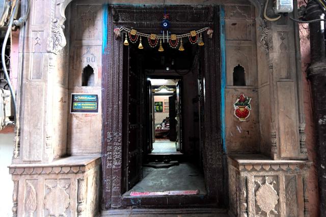 This photograph taken on February 5, 2026 shows a man sitting inside a century-old haveli in the old quarters of Delhi. Once the grand residences of Mughal-era nobility, the Indian capital's haveli homes now stand at fragile crossroads -- a handful lovingly restored but many more sliding quietly into ruin. (Photo by Manan VATSYAYANA / AFP)