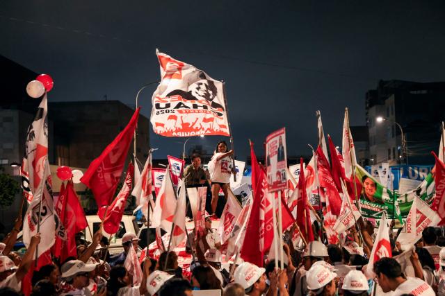 Supporters of Peru's presidential candidate Alfonso Lopez-Chau, from the Ahora Nacion party, wave flags outside the Lima Convention Center during the first round of debates on tackling crime and corruption in Lima on March 23, 2026, ahead of the April 12 general election. (Photo by Connie FRANCE / AFP)