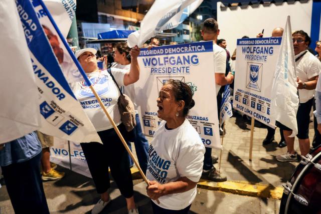 A supporter of Peru's presidential candidate Wolfgang Grozo, for the Integridad Democratica party, shouts slogans outside the Lima Convention Center during the first round of debates on tackling crime and corruption in Lima on March 23, 2026, ahead of the April 12 general election. (Photo by Connie FRANCE / AFP)