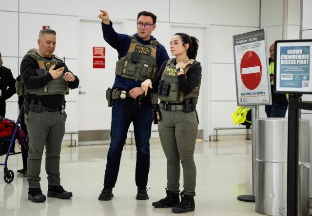 Federal law enforcement agents stand inside Newark Liberty International Airport in Newark, New Jersey, on March 23, 2026. Immigration agents will be deployed in US airports beginning Monday, aiming to alleviate soaring congestion at security screenings amid a weeks-long budget standoff over President Donald Trump's mass deportation drive, officials said. (Photo by kena betancur / AFP)