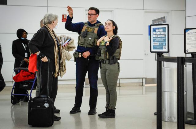 Federal law enforcement agents assist a traveller inside Newark Liberty International Airport in Newark, New Jersey, on March 23, 2026. Immigration agents will be deployed in US airports beginning Monday, aiming to alleviate soaring congestion at security screenings amid a weeks-long budget standoff over President Donald Trump's mass deportation drive, officials said. (Photo by kena betancur / AFP)