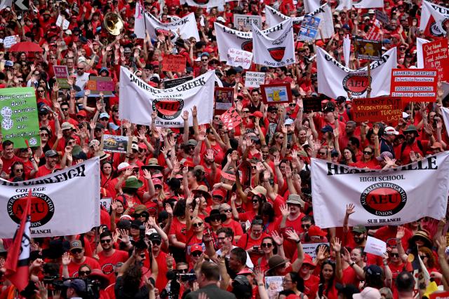 Teachers march through Melbourne's city centre to protest over pay and conditions on March 24, 2026. Tens of thousands of public school teachers went on strike for the first time in thirteen years following a pay dispute with the state government, closing or disrupting some 500 state schools. (Photo by William WEST / AFP)