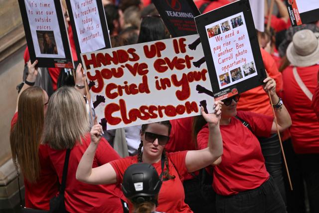 Teachers march through Melbourne's city centre to protest over pay and conditions on March 24, 2026. Tens of thousands of public school teachers went on strike for the first time in thirteen years following a pay dispute with the state government, closing or disrupting some 500 state schools. (Photo by William WEST / AFP)