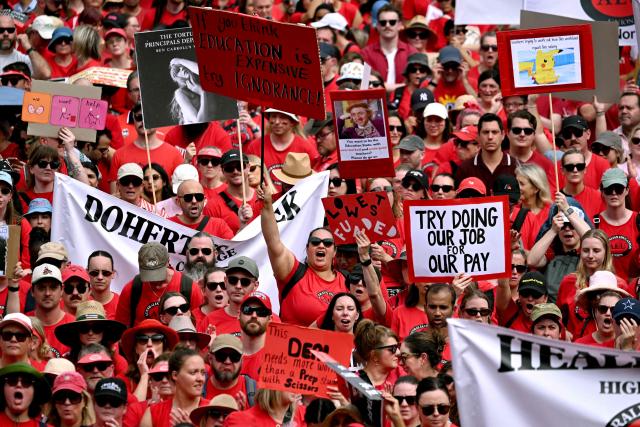 Teachers march through Melbourne's city centre to protest over pay and conditions on March 24, 2026. Tens of thousands of public school teachers went on strike for the first time in thirteen years following a pay dispute with the state government, closing or disrupting some 500 state schools. (Photo by William WEST / AFP)