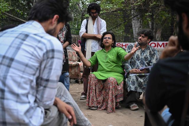 This photograph taken on March 18, 2026 shows activist Ritu (L) and PhD scholar Vaibhav Das, who identify as non-binary interacting with students on the proposed Transgender Persons (Protection of Rights) Amendment Bill in New Delhi. A proposed amendment to India's transgender law has sparked fear and anger among LGBTQ groups, who warn it could undo hard-won legal gains and take away the right to self-identify. (Photo by Arun SANKAR / AFP)