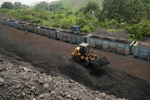 (FILES) A worker operates a wheel loader to convey heaps of raw coal into train carriages, excavated from an open-cast mine on the outskirts of Dhanbad, in India's Jharkhand state on August 13, 2025. Asian countries are ramping up use of polluting coal to tackle energy shortages and price spikes linked to the Iran war, but the crisis could have an environmental silver lining. (Photo by Vishal kumar singh / AFP)