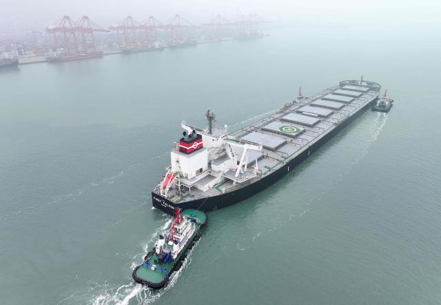 Tugboats lead a ship to its berth at the container terminal in Lianyungang, eastern China's Jiangsu province on March 24, 2026. (Photo by CN-STR / AFP) / China OUT