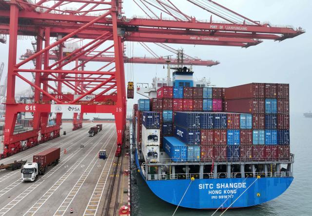 A ship (R) full of containers is seen at the container terminal in Lianyungang, eastern China's Jiangsu province on March 24, 2026. (Photo by CN-STR / AFP) / China OUT
