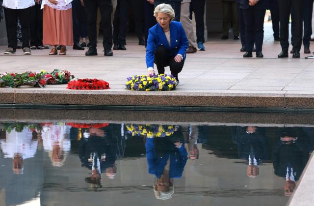 European Commission President Ursula von der Leyen (C) lays a wreath during her visit to the Australian War Memorial in Canberra on March 24, 2026. (Photo by DAVID GRAY / AFP)