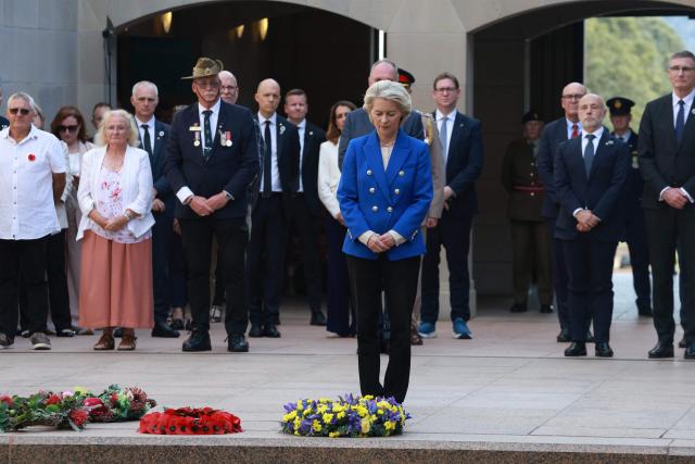 European Commission President Ursula von der Leyen (C) pays her respects after laying a wreath during her visit to the Australian War Memorial in Canberra on March 24, 2026. (Photo by DAVID GRAY / AFP)