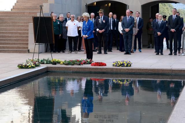 European Commission President Ursula von der Leyen (C) pays her respects after laying a wreath during her visit to the Australian War Memorial in Canberra on March 24, 2026. (Photo by DAVID GRAY / AFP)