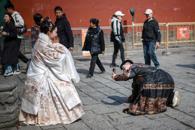 Tourists dressed in imperial outfits take pictures at the Shenyang imperial palace or Mukden palace in Shenyang, northern China's Liaoning province on March 23, 2026. (Photo by CN-STR / AFP) / China OUT