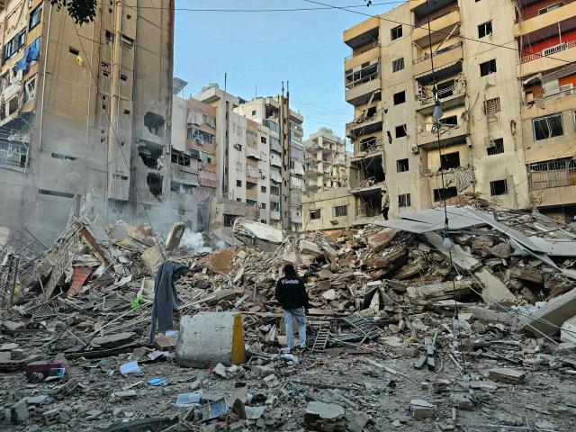 A man looks at debris at the site of an overnight Israeli airstrike in Beirut's southern suburb of Bir al Abed on March 24, 2026. An Israeli strike on Bshamoun, south of Beirut, killed two people on March 24, Lebanon's health ministry said, while strikes on the capital's southern suburbs continued throughout the night. (Photo by AFP) / 