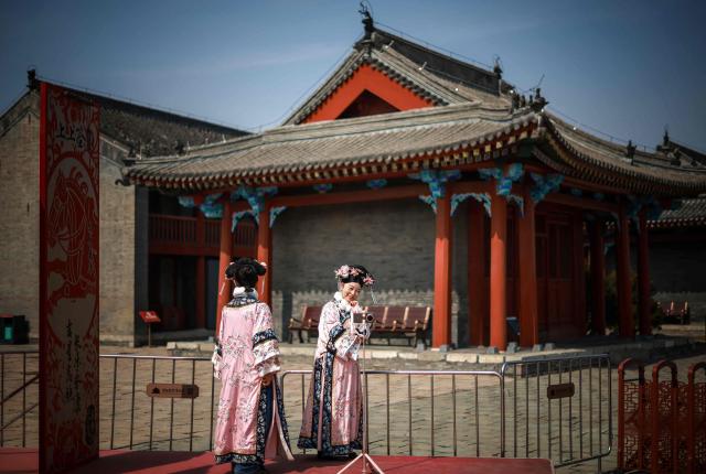 Tourists dressed in imperial outfits take picture at the Shenyang imperial palace or Mukden palace in Shenyang, northern China's Liaoning province on March 23, 2026. (Photo by CN-STR / AFP) / China OUT