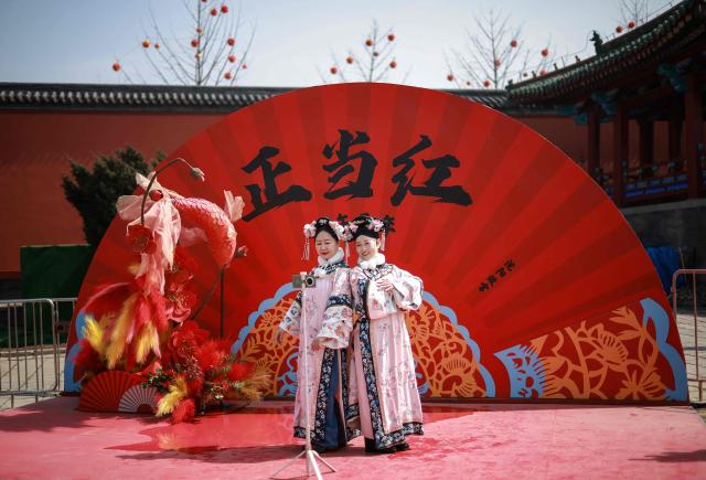 TOPSHOT - Tourists dressed in imperial outfits take picture at the Shenyang imperial palace or Mukden palace in Shenyang, northern China's Liaoning province on March 23, 2026. (Photo by CN-STR / AFP) / China OUT