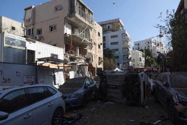Israeli emergency service personnel gather at the site of an Iranian missile strike in Tel Aviv on March 24, 2026. First responders said six people were injured on March 24 in Israel's commercial hub Tel Aviv, where police reported several impact sites after the military warned of incoming missile fire from Iran. Iran launched a new wave of missiles against Israel on March 24, hours after US President Donald Trump hailed "very good" talks to end the war despite Tehran denying any dialogue had taken place. (Photo by Jack GUEZ / AFP) / 