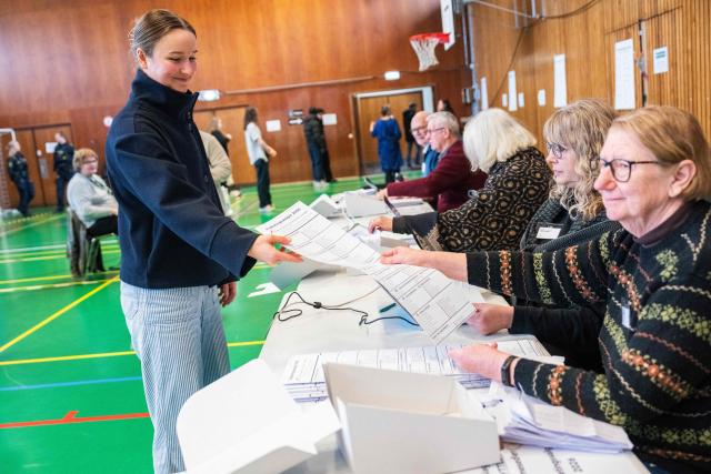 A woman picks up her ballot to vote in Copenhagen's Broenshoej district, on March 24, 2026, during the parliamentary election in Denmark. (Photo by Martin Sylvest / Ritzau Scanpix / AFP) / Denmark OUT