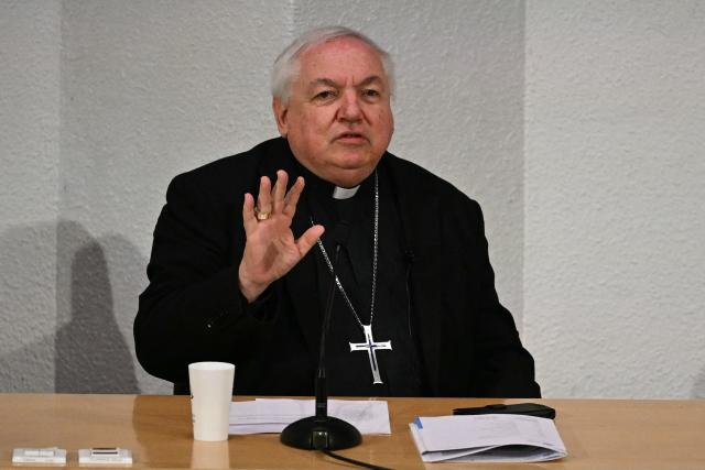 The president of the conference of bishops of France, Cardinal Jean-Marc Aveline (C), speaks during the opening speech of the plenary assembly of the bishops of France in Lourdes, on March 24, 2026. (Photo by LIONEL BONAVENTURE / AFP)