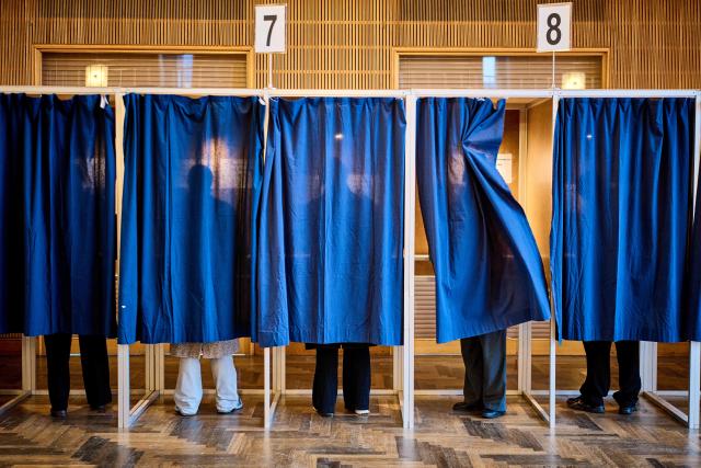 People cast their votes at a polling station at Aarhus City Hall, on March 24, 2026, during the parliamentary election in Denmark. Danes began voting on March 24, 2026 in general elections, with Prime Minister Mette Frederiksen seen as the favourite after standing up to US President Donald Trump over Greenland. (Photo by Mikkel Berg Pedersen / Ritzau Scanpix / AFP) / Denmark OUT