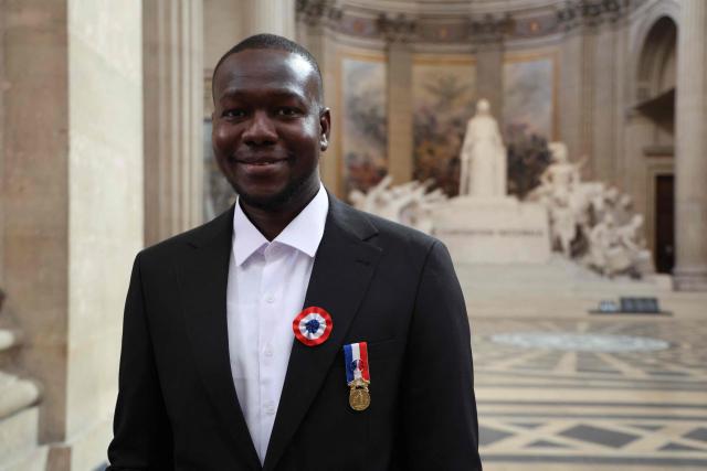 Fousseynou Cisse attends a naturalization ceremony presided over by French Interior Minister at the Pantheon in Paris on March 24, 2026. Cisse, a 39-year-old Senegalese man, rescued six people—four children and their two mothers from a fire in their apartment in Paris on July 4, 2025. The rescue, filmed by a resident, quickly went viral on social media. (Photo by Ludovic MARIN / AFP)