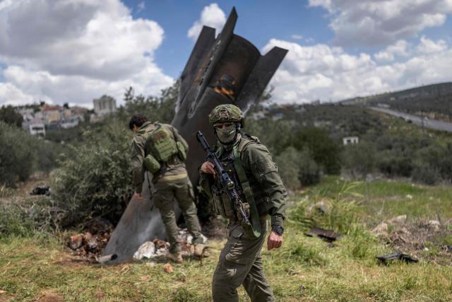 Israeli soldiers arrive to check an Iranian missile fragment that landed in the Israeli-occupied West Bank village of Hares on March 24, 2026. Since the United States and Israel unleashed strikes on Iran on February 28, war has spread across the Middle East, with casualties reported in countries across the region. (Photo by Ilia YEFIMOVICH / AFP)