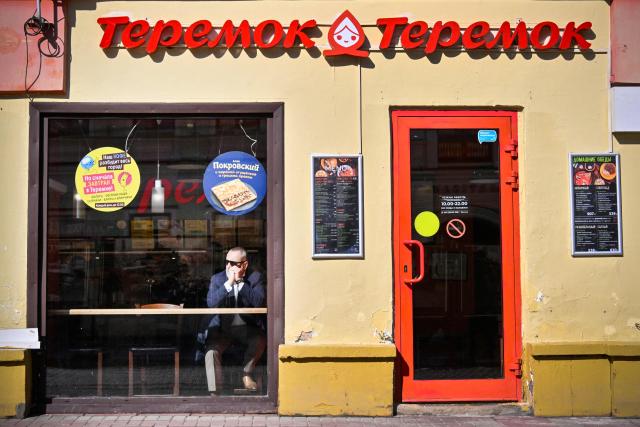A man sits inside a Russian fast-food chain Teremok cafe at the touristic Arbat street in downtown Moscow on March 24, 2026. (Photo by Alexander NEMENOV / AFP)