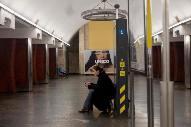 A woman takes shelter at a metro station during an air strike alarm in Kyiv on March 24, 2026, amid the Russian invasion of Ukraine. (Photo by Tetiana DZHAFAROVA / AFP)