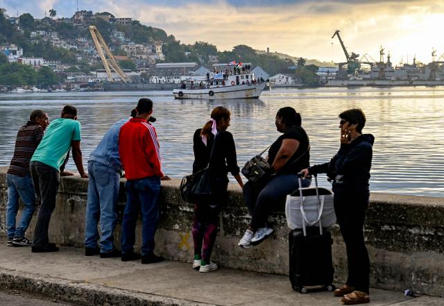 People watch the vessel Maguro, arriving from Mexico with humanitarian aid as part of the Nuestra America convoy, docking at the port of Havana on March 24, 2026. (Photo by YAMIL LAGE / AFP)