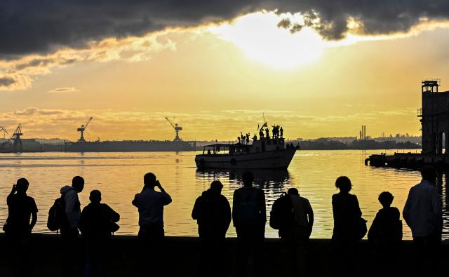 People watch the vessel Maguro, arriving from Mexico with humanitarian aid as part of the Nuestra America convoy, docking at the port of Havana on March 24, 2026. (Photo by YAMIL LAGE / AFP)