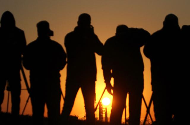 News media gather to view the NASA's Artemis II Space Launch System (SLS) rocket and Orion spacecraft at Launch Pad 39B at sunrise at the Kennedy Space Center in Cape Canaveral, Florida on March 24, 2026. NASA on March 19 began returning its towering SLS rocket and Orion spacecraft to its Florida launch pad ahead of a planned flyby of the Moon, after completing necessary repairs. The next launch window opens on April 1. (Photo by Gregg Newton / AFP)