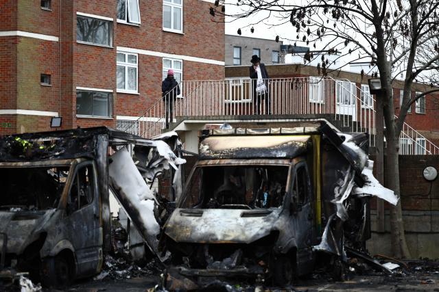A member of the Jewish community uses a phone on a footbridge above the scene of an antisemitic arson attack in the Golders Green neighbourhood of north London, on March 24, 2026, an incident where volunteer ambulances run by a Jewish organisation were set on fire the previous night. Britain's Prime Minister Keir Starmer on March 23 condemned "a deeply shocking antisemitic arson attack" on volunteer ambulances run by a Jewish organisation in London. (Photo by Henry Nicholls / AFP)