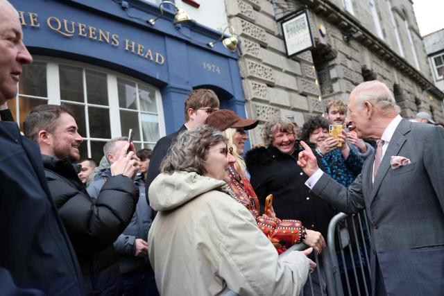 Britain's King Charles III meets members of the public outside the Queens Head pub during a visit to St Austell, south-west England on March 24, 2026. (Photo by Adrian DENNIS / POOL / AFP)
